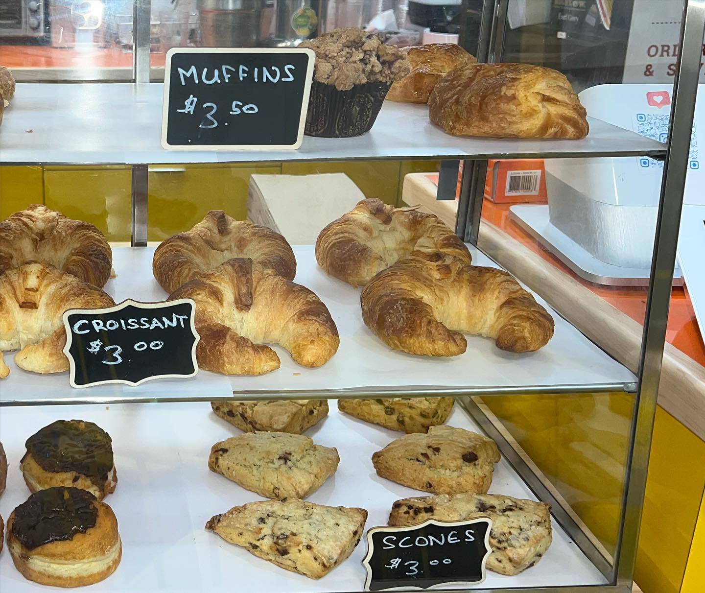 The pastry case at Sunshine Café — croissants, muffins, scones